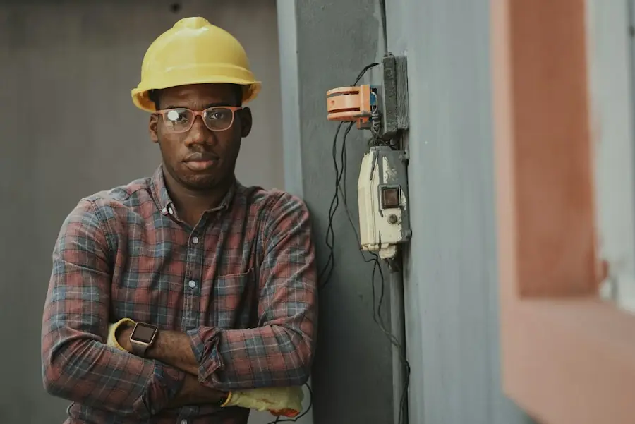 Engineer in a yellow hard hat and safety glasses standing beside site equipment